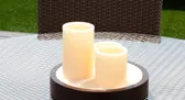 Velas decorativas encendidas sobre una mesa de terraza.